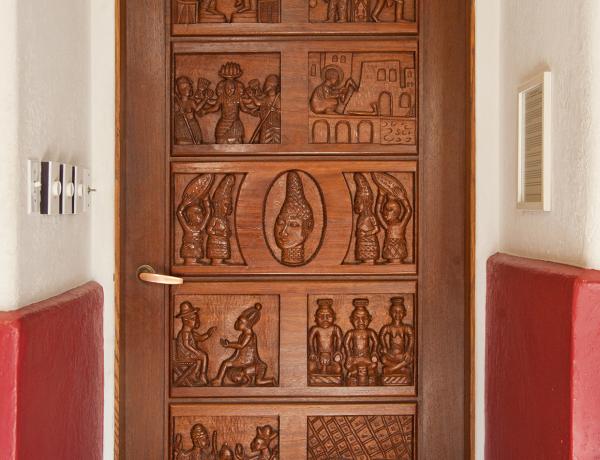 Elaborately carved door with scenes of human figures.